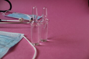 two vials with a vaccine on a pink background with a place for the text of the copyspace