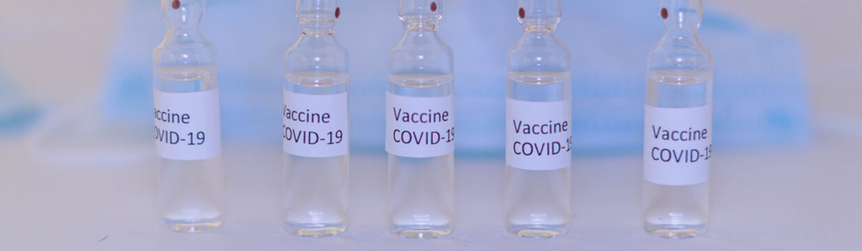 ampoules with Covid-19 vaccine on a laboratory on the table, syringe banner