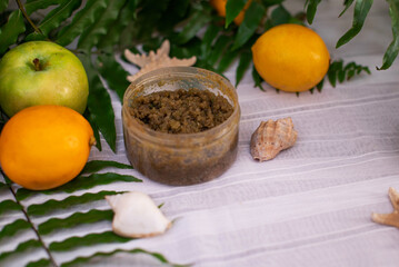 image of homemade cosmetics ingredients. aroma theme. organic cosmetics with extracts of herbs apples, lemons and oranges on white leaf green background