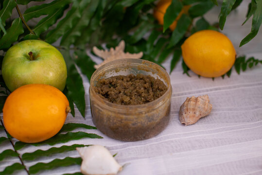 image of homemade cosmetics ingredients. aroma theme. organic cosmetics with extracts of herbs apples, lemons and oranges on white leaf green background