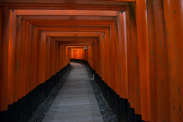 Beautiful and peaceful Fushimi Inari shrine near Kyoto, Japan.  Tunnel of red torii gates.