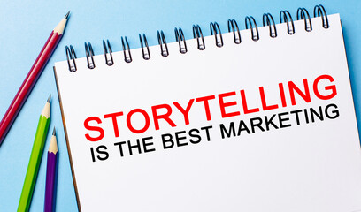 Text Storytelling is the best marketing on a white notepad with pencils on a blue background. Business concept