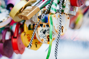 Many bright, colored  iron  love romantic padlocks, wedding padlocks, love locks. Symbol of eternal love hanging on the railing. Together forever