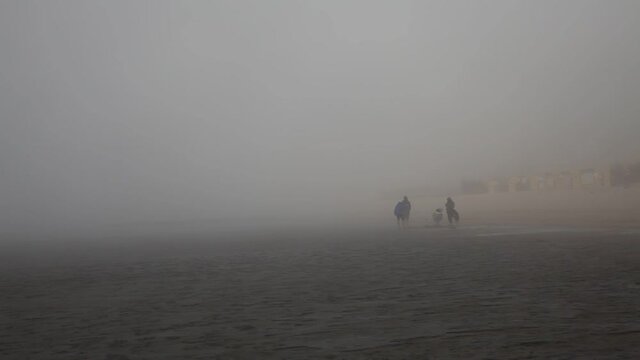 Menschen in einer Nebelbank an der Nordsee