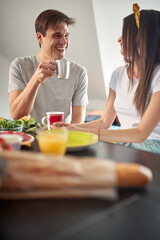 A young couple enjoying a chat and a coffee before breakfast at home. Couple, relationship, breakfast, together