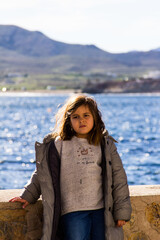 Fototapeta na wymiar portrait of quiet girl in warm clothes by the sea