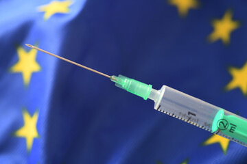 Hamburg, Germany - January 29, 2021:  An injection and a EU flag, which should symbolize the legal...