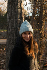 Smiling woman leaning against the trunk of a tree