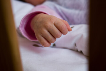 New born baby hand in the cradle, cot
