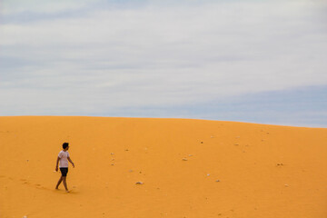 Fototapeta na wymiar boy walking in the distance through a desert