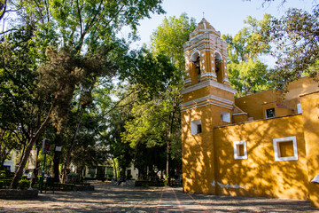 Naklejka premium Old Mexican Church surrounded by trees in Coyoacan