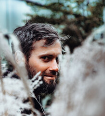Artistic photo portrait confident smiling handsome middle-aged Caucasian man portraited in the city, with white skin, grey and black hair having a friendly look on his face, wearing a blue jacket.