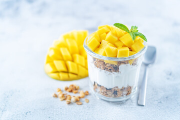 Mango Greek yogurt granola parfait in a glass