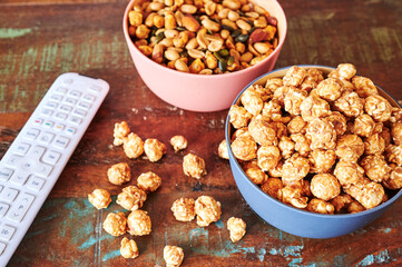 Wooden table with snacks and a TV remote control.