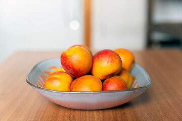 Ripe bright apricots on a table in a plate