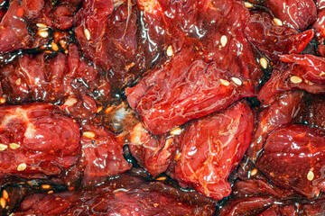 Obraz na płótnie Canvas Bright, juicy marinated slices of beef with spices, oil and sesame seeds