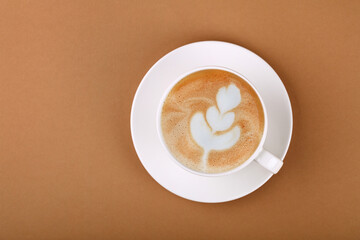 Cup of cappuccino coffee on white saucer