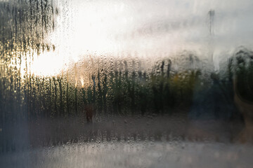 Condensation on the outside of double glazed window glass at sunrise. 