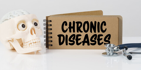 On the table lies a skull, a stethoscope and a notebook with the inscription - CHRONIC DISEASES