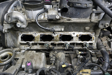 A partially disassembled engine of a modern car is ready for repair. The engine is dirty. Car service, spare parts.