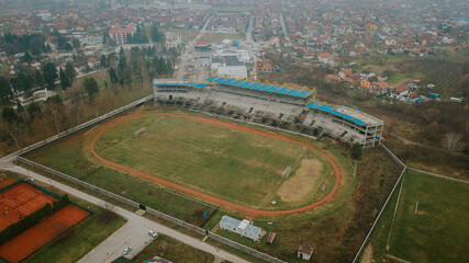 Aerial shot of a stadium surrounded by buildings and trees