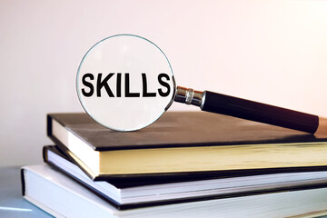 The inscription SKILLS is written on the immortal glass that lies on the books. Content lettering...