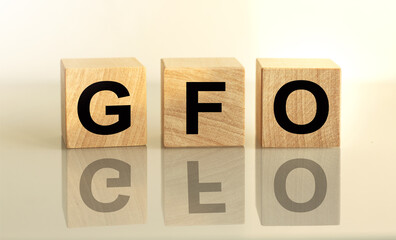 The inscription GFO on wooden cubes isolated on a light background, the concept of business and finance.