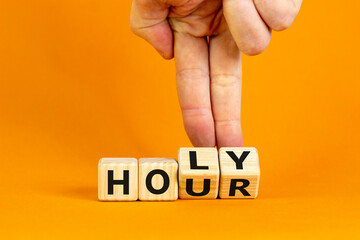 Holy hour symbol. Hand turns wooden cubes with words holy hour. Beautiful orange background, copy space. Religion and holy hour concept.