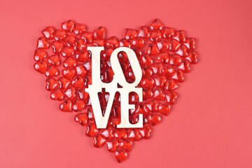Wraped wooden word LOVE on red heart background.