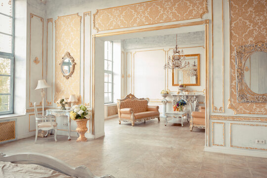 very rich interior of the apartment with golden decorations on the walls in the Baroque style and luxury furniture with gold paint.