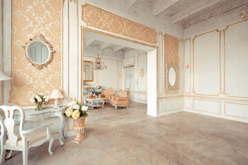 very rich interior of the apartment with golden decorations on the walls in the Baroque style and luxury furniture with gold paint.