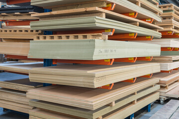 Construction sheet materials stored on cantilever rack in joinery workshop. - obrazy, fototapety, plakaty