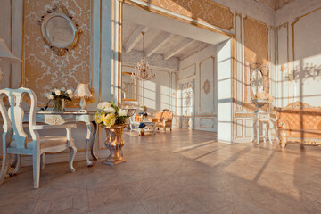 rich apartment interior with golden baroque decorations on the walls and luxury furniture. the room is flooded with the rays of the setting sun