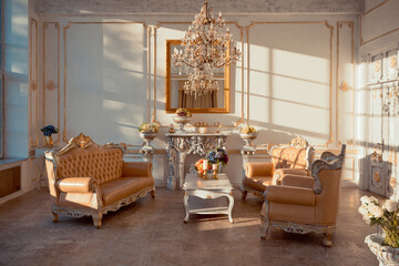 rich apartment interior with golden baroque decorations on the walls and luxury furniture. the room is flooded with the rays of the setting sun