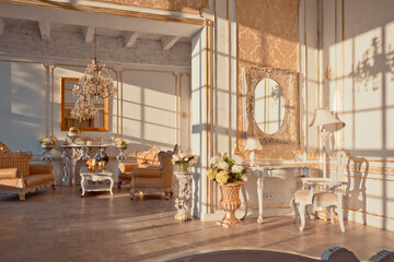 rich apartment interior with golden baroque decorations on the walls and luxury furniture. the room is flooded with the rays of the setting sun