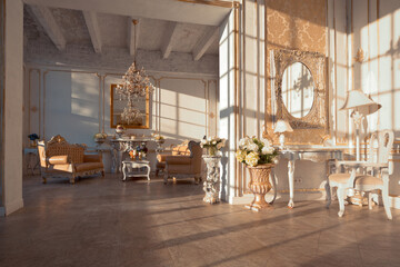 rich apartment interior with golden baroque decorations on the walls and luxury furniture. the room is flooded with the rays of the setting sun