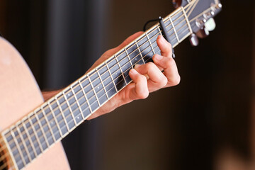 Close-up shot of a guitar and musician's fingers on wires at a happy hour party. 