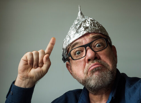 Crazy Man Conspiracy Therapist In A Protective Cap Made Of Foil. Fake News Concept