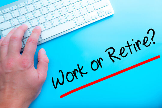 Work or Retire? Sign Working at home with computer man writing. Man hands on the keyboard. Isolated on blue background.   Business concept. Stock Photo