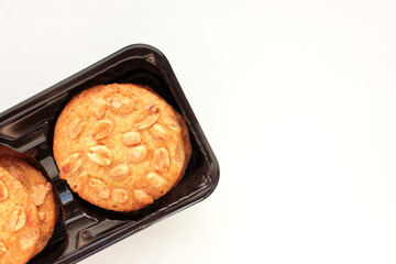 Peanut cookies in a box. Biscuits pack on white background. Overhead view, copy space
