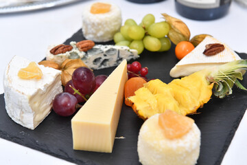 Catering. Colorful meat snacks with bread fruits and vegetables on a white plate.