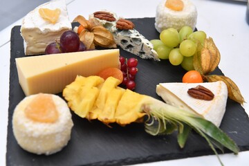 Catering. Colorful meat snacks with bread fruits and vegetables on a white plate.