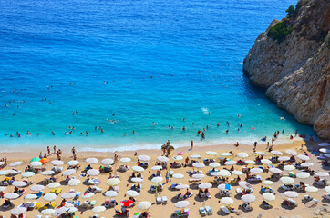 People swim in the azure sea and sunbathe on Kaputas beach in Turkey. Rocks, sea, sun