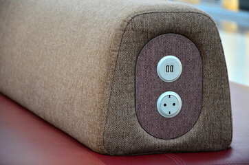 Phone charging and a 220 V electrical outlet built into the grey back of the red sofa