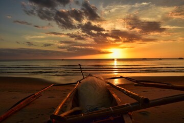 Filipino fishing boat at sunset on the sugar beach, Fishing boat on the beautiful sandy coast of...