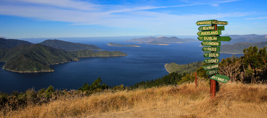 International directional signs and Queen Charlotte Sound, New Zealand.
