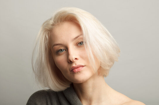 Middle Aged Attractive Blonde Caucasian Woman Face Isolated On Gray Background, Close Up Portrait