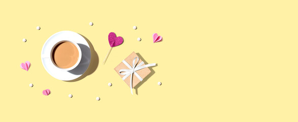 A cup of coffee with a gift box and hearts - flat lay