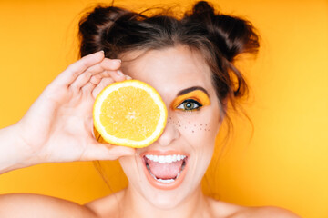 Frau mit Orange Obst gelb weiße Zähne Make Up braune Haare lustig frech freundlich