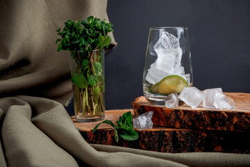 Mojito cocktail on a dark background. Wooden stand.